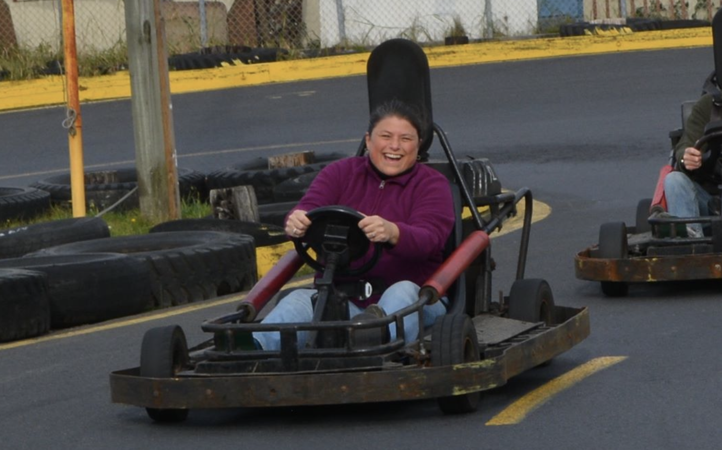 Teresa laughing while driving a go-kart